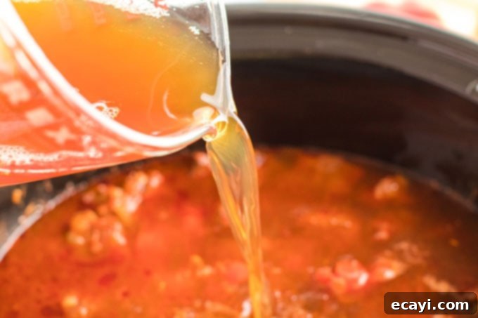 Hearty Slow Cooker Hungarian Goulash with Noodles 10 adding broth to crockpot
