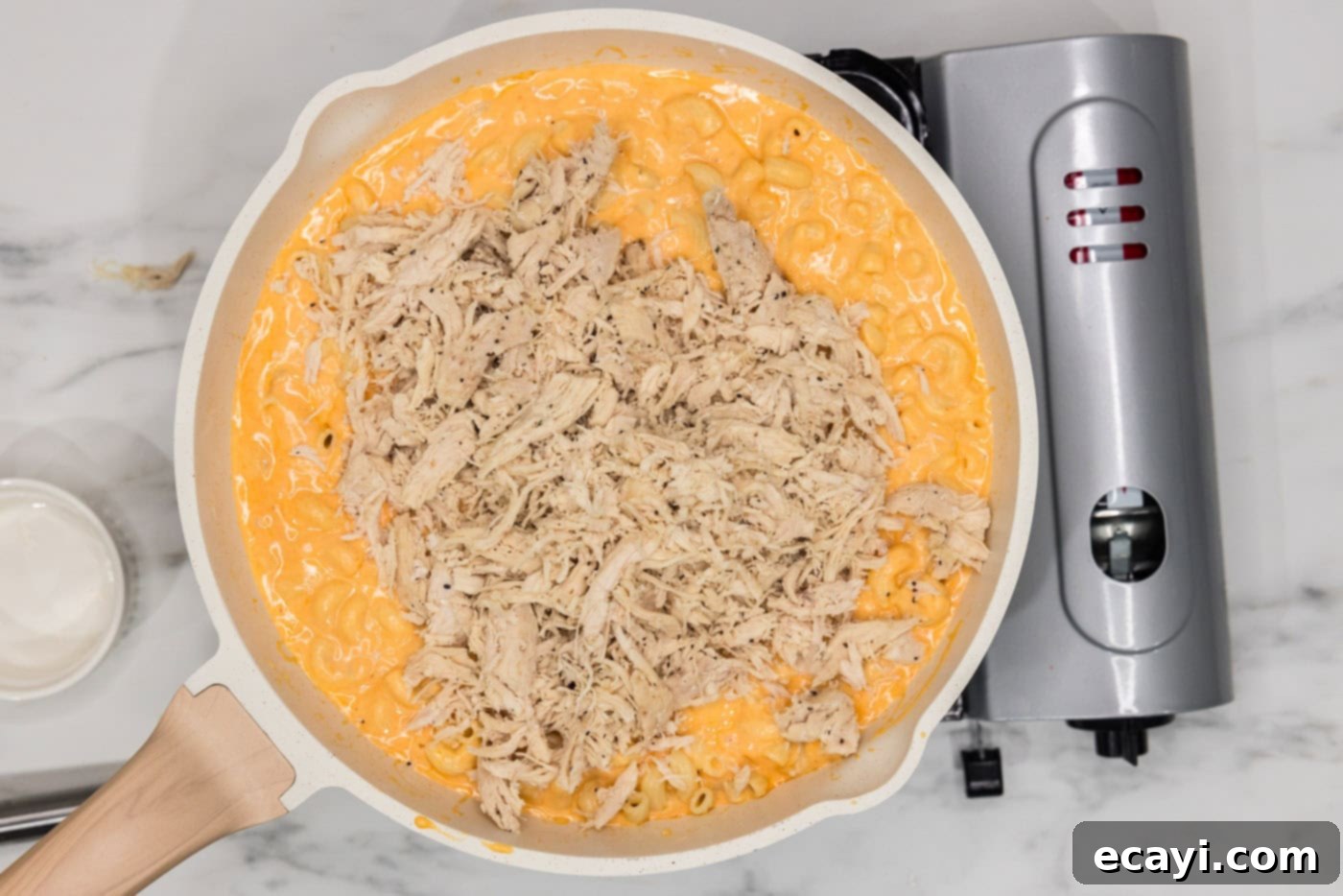 Buffalo Mac Bliss 11 shredded chicken added to skillet of buffalo mac and cheese