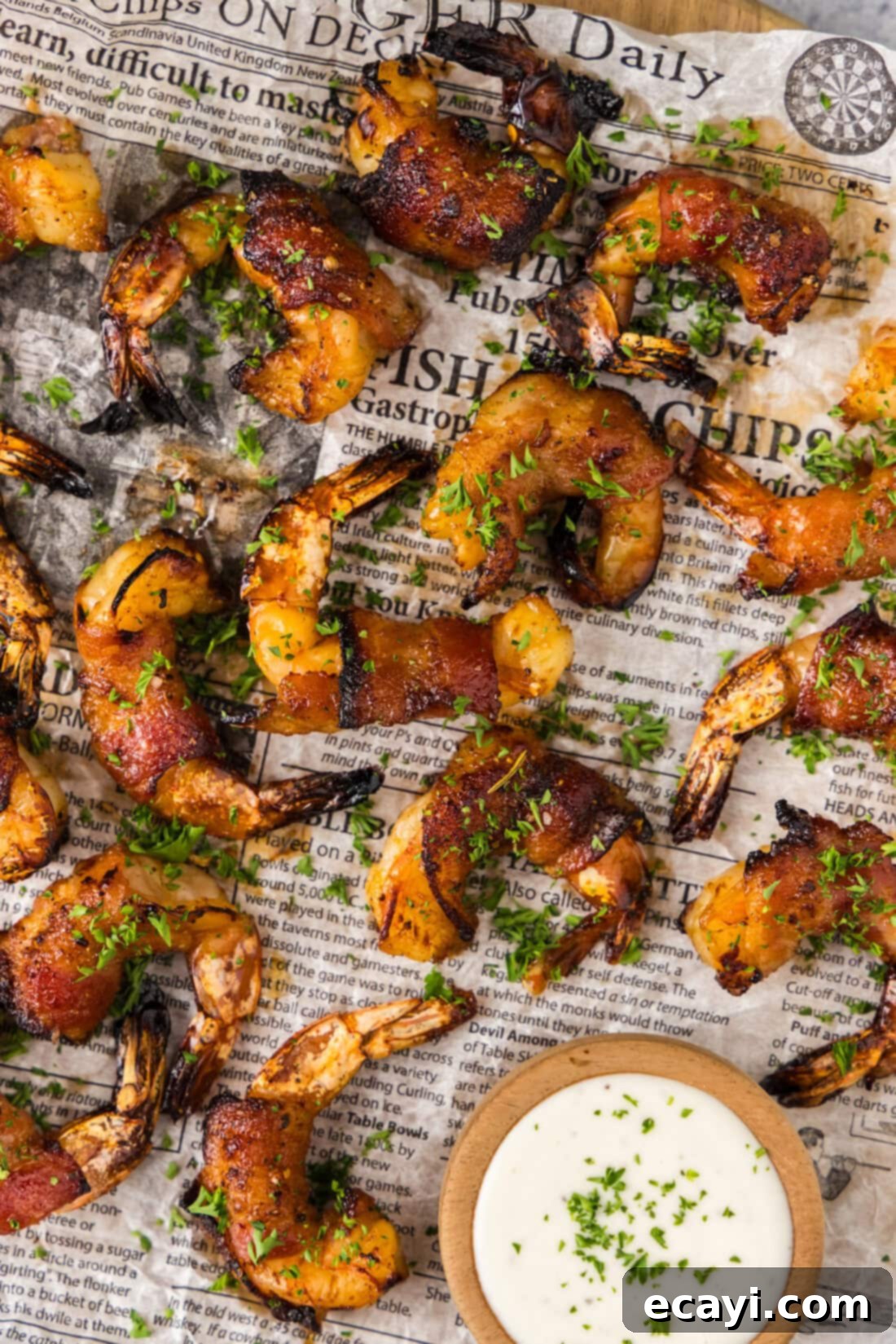 Crispy Air Fryer Bacon Wrapped Shrimp 2 Close up photo of Air Fryer Bacon Wrapped Shrimp on parchment paper, perfectly golden and glazed.