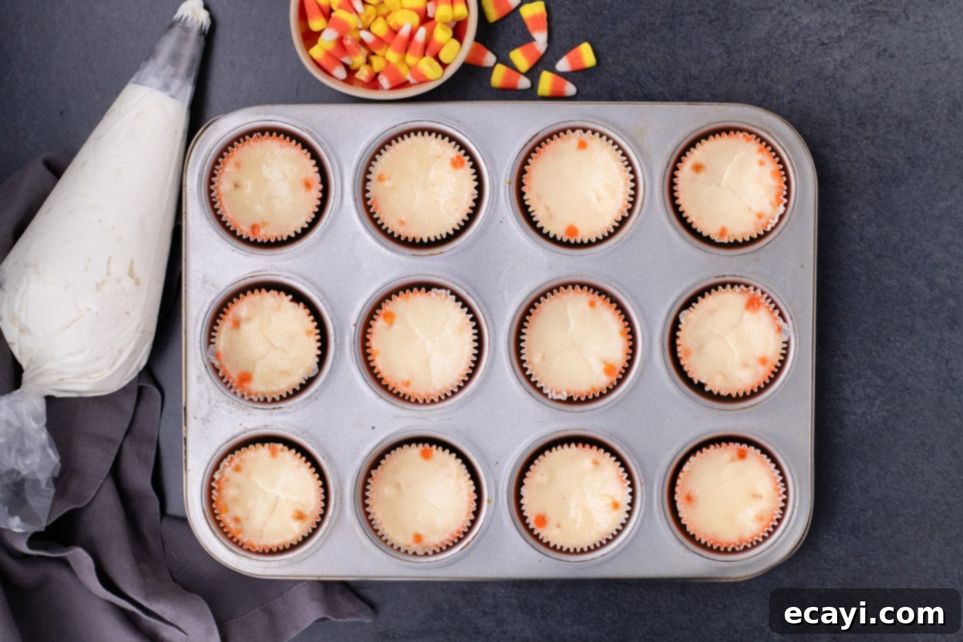 Festive Candy Corn Mini Cheesecakes 13 Mini candy corn cheesecakes, cooled and set, remaining in the cupcake pan after their slow cool-down period in the oven.