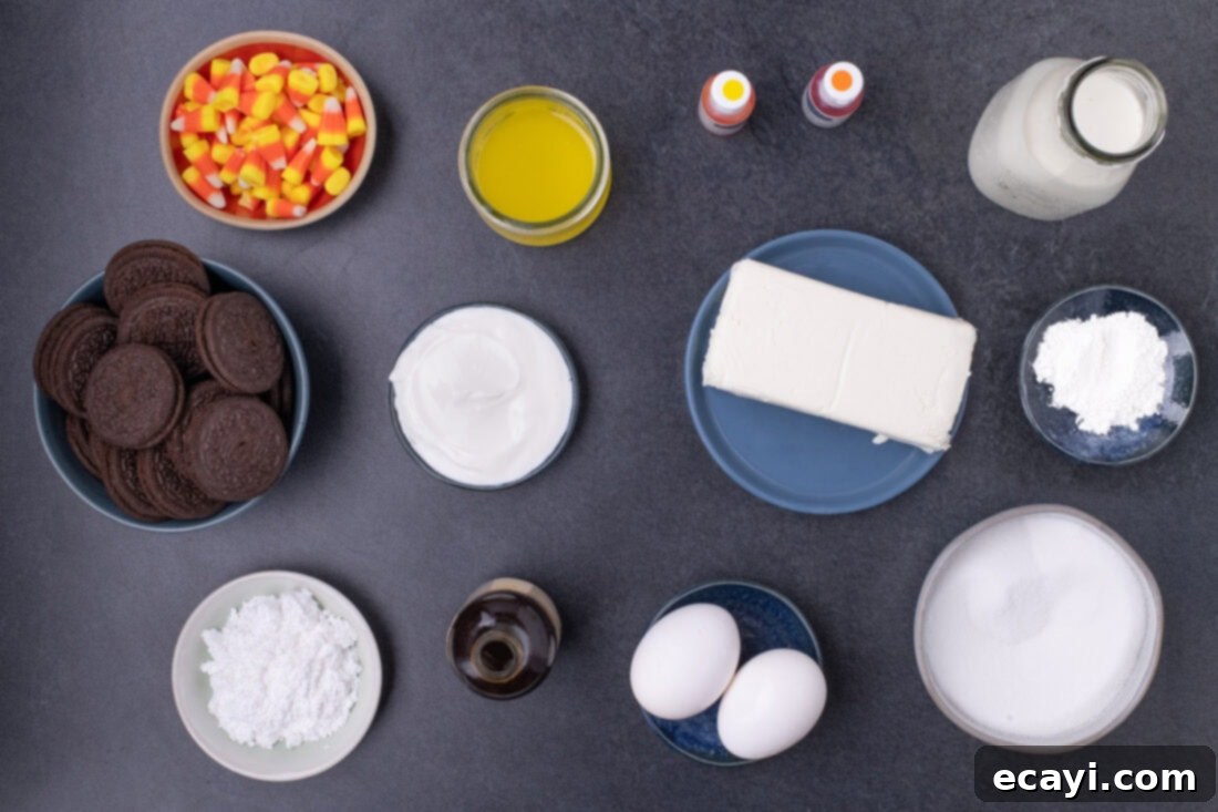 Festive Candy Corn Mini Cheesecakes 4 An organized flat lay displaying all the necessary ingredients for Mini Candy Corn Cheesecakes, including Oreos, butter, cream cheese, sour cream, sugar, flour, vanilla, eggs, and gel food coloring.