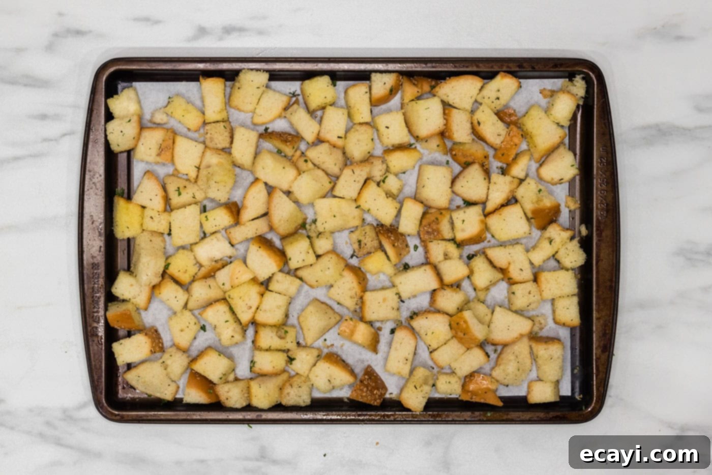 Crispy Golden Croutons 10 seasoned cubed bread on a baking sheet