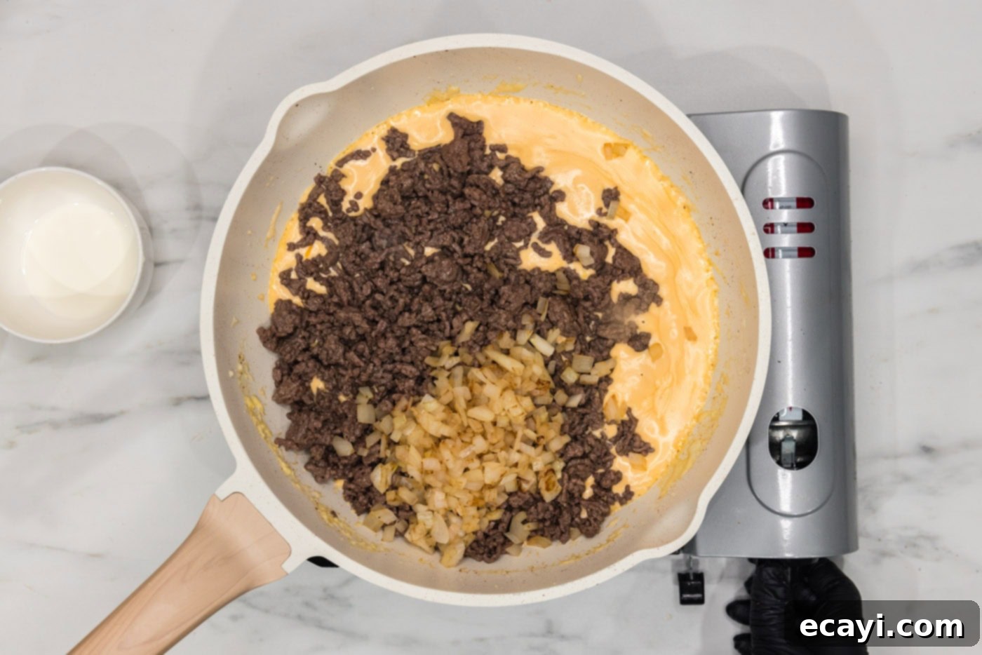 Loaded Cheeseburger Dip 9 ground beef and onions added to cream cheese mixture in a skillet