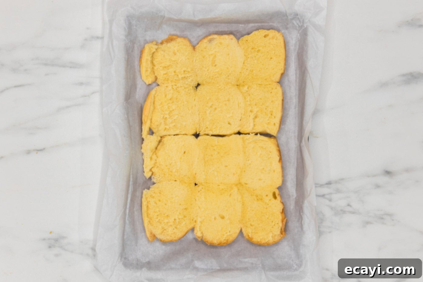 Cheesy Chicken Parmesan Sliders 5 Slider buns neatly arranged in a parchment-lined baking dish