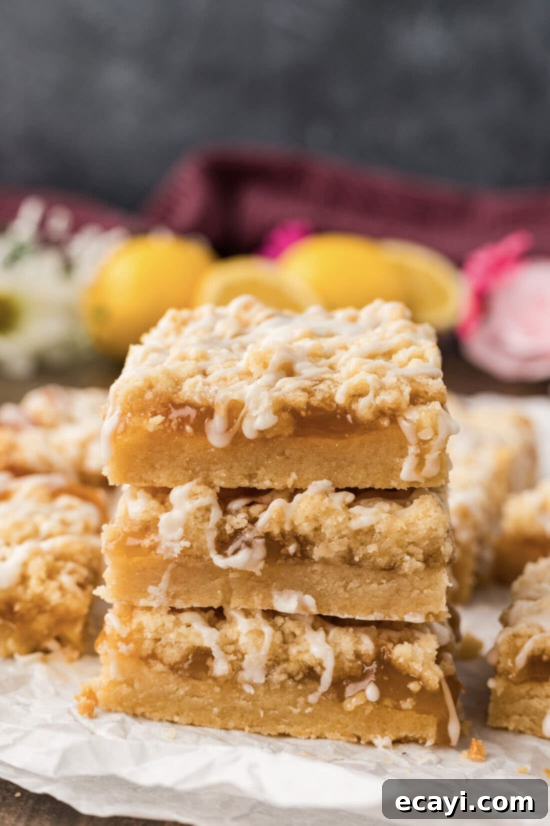 Zesty Lemon Crumble Bars 2 Stack of three Lemon Streusel Squares, showcasing the layers of buttery crust, tangy lemon curd, and delicate streusel topping with a sweet lemon drizzle.