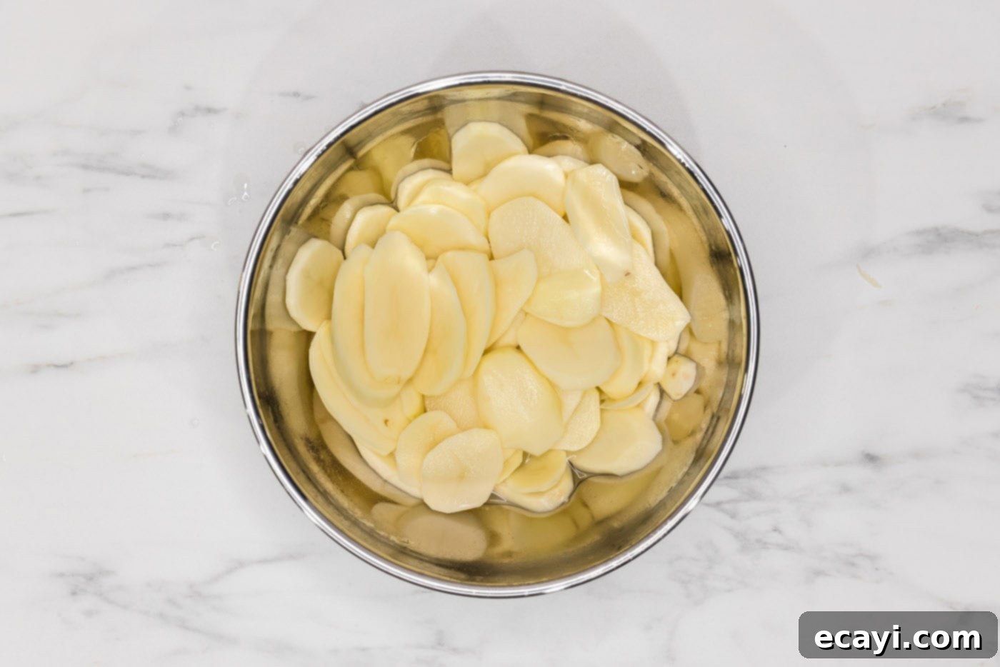 Set It and Forget It Scalloped Potatoes 5 thinly sliced potatoes in a bowl