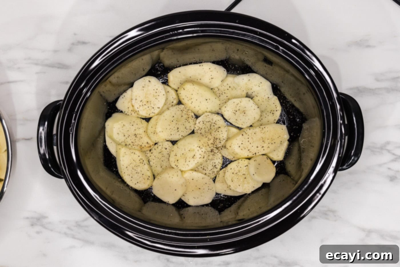 Set It and Forget It Scalloped Potatoes 10 seasoned and sliced potatoes in a crock of a slow cooker