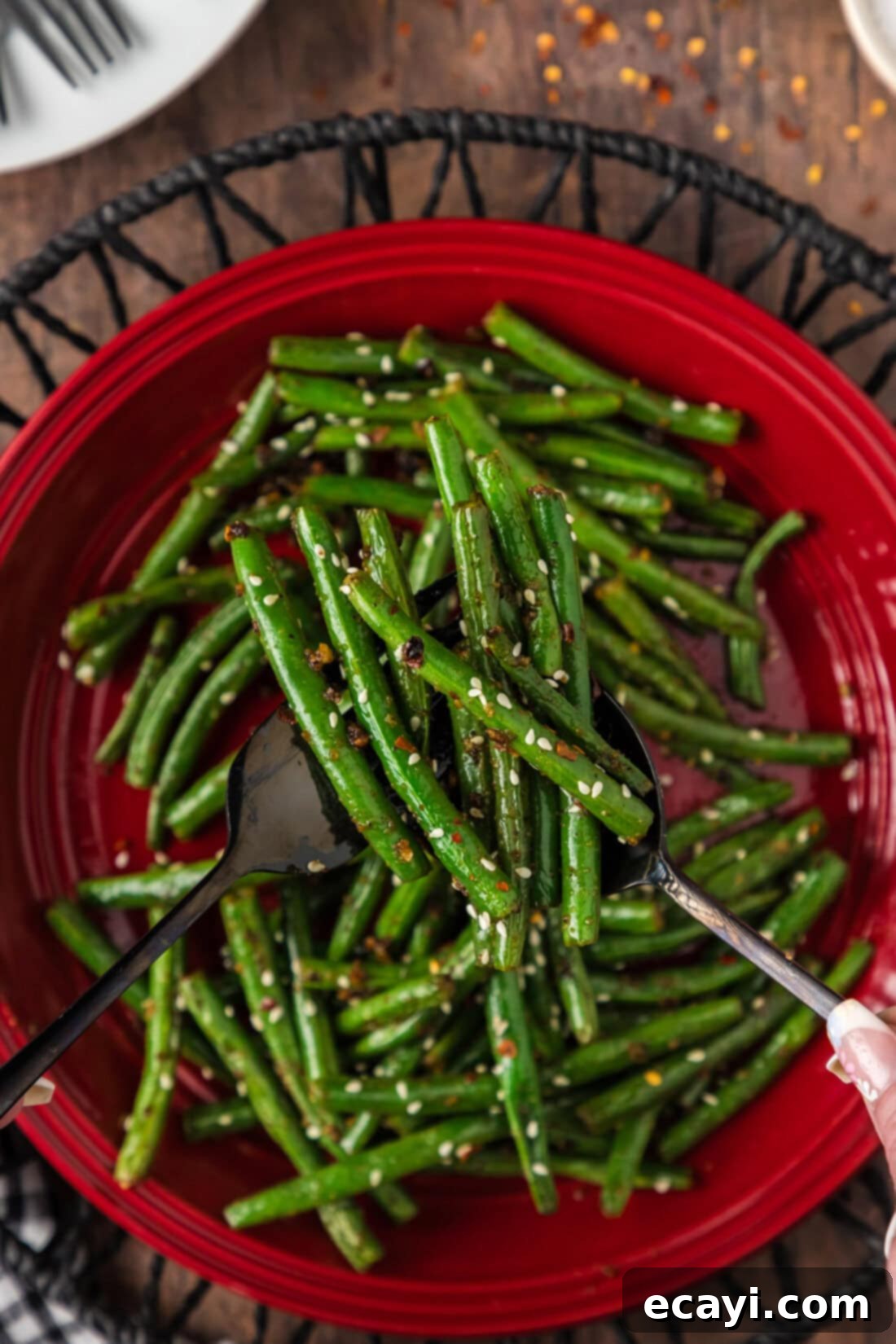 Garlic Sauteed Green Beans 3 Serving utensils holding up Sautéed Green Beans above a plate