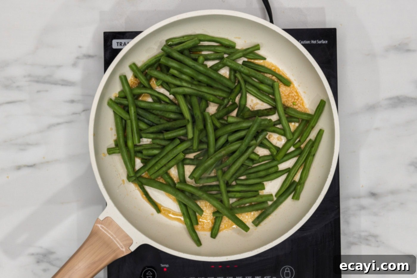 Garlic Sauteed Green Beans 5 green beans in a skillet with garlic and sesame oil