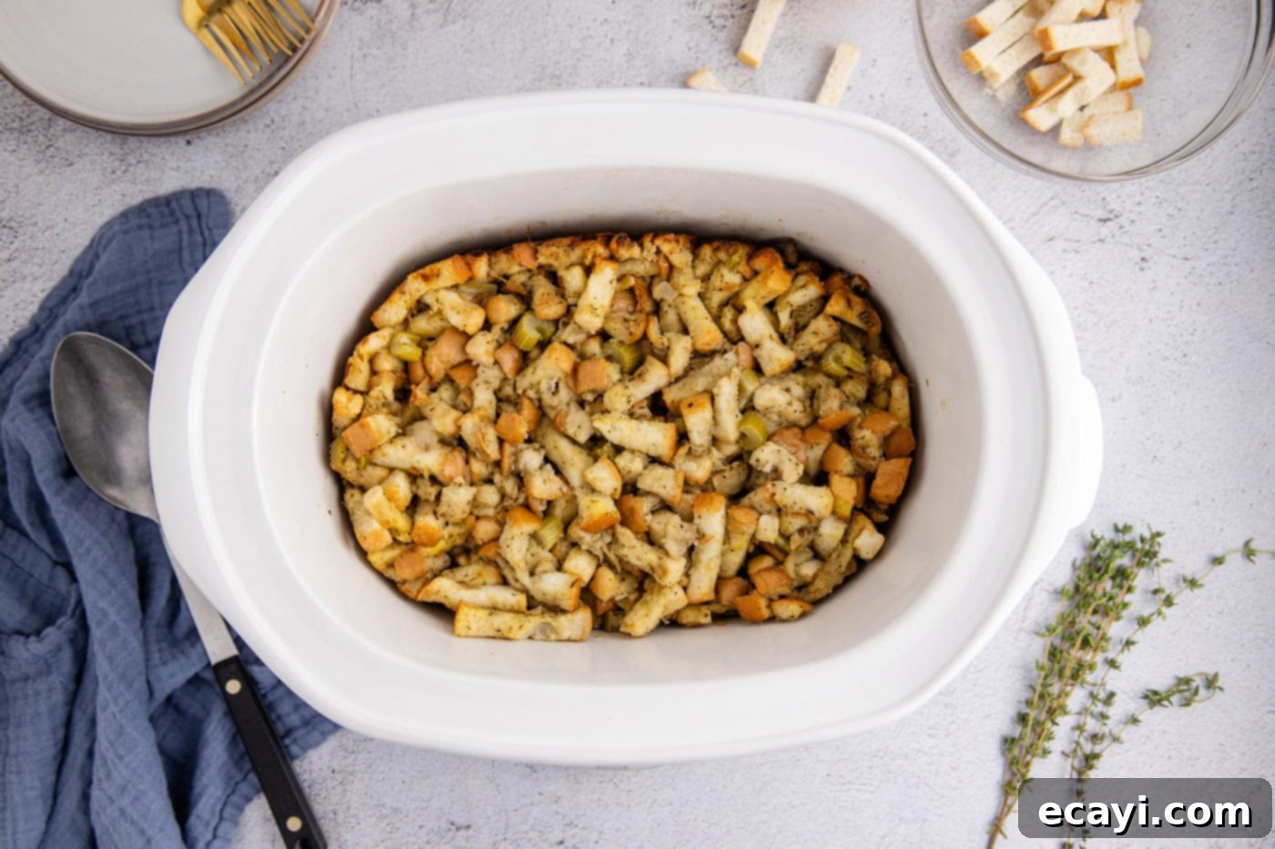 Easy Crockpot Stuffing 11 Cooked crockpot stuffing, viewed from overhead, garnished with fresh herbs.