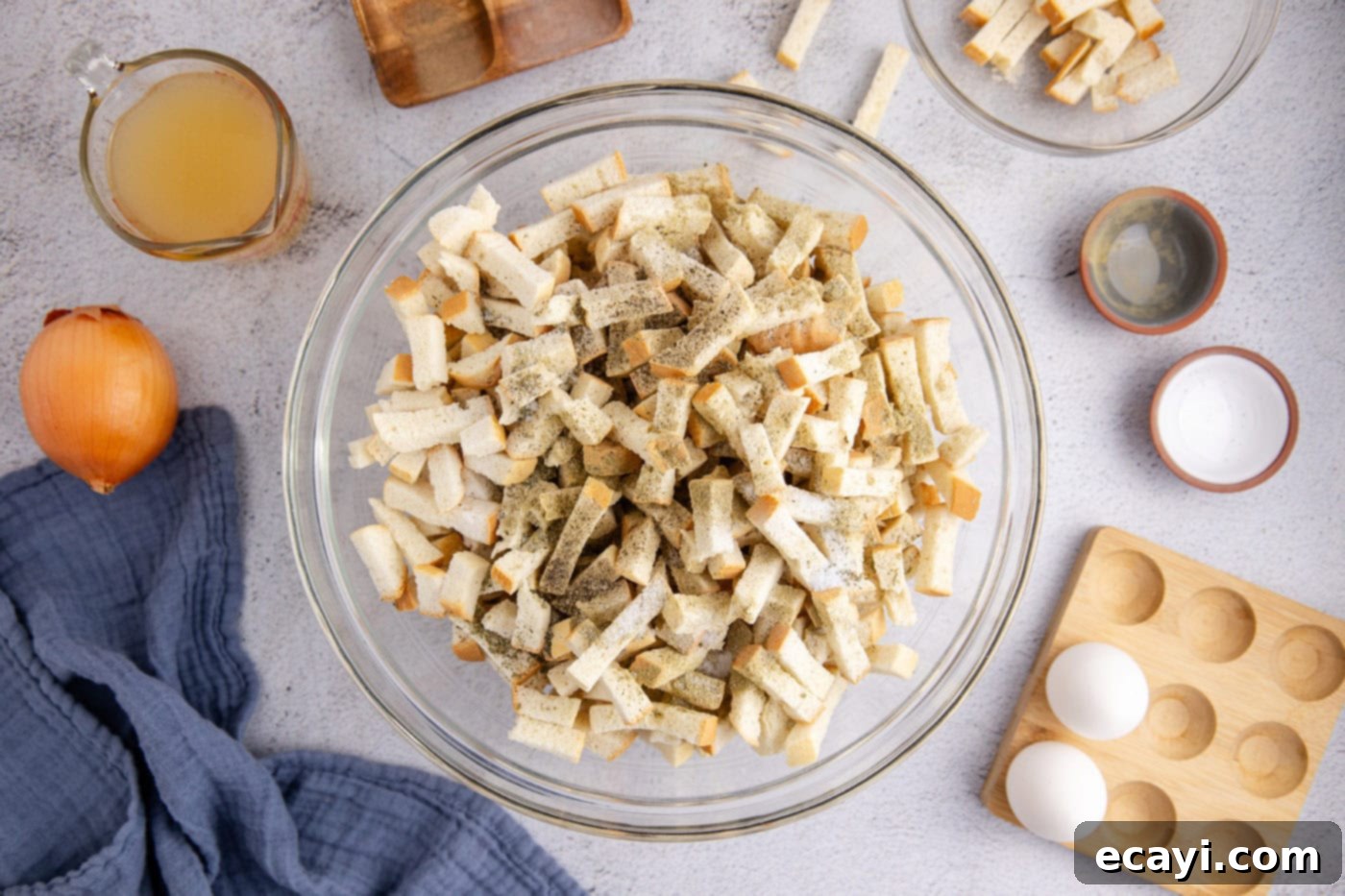 Easy Crockpot Stuffing 7 Dried bread cubes in a bowl with various seasonings sprinkled on top.