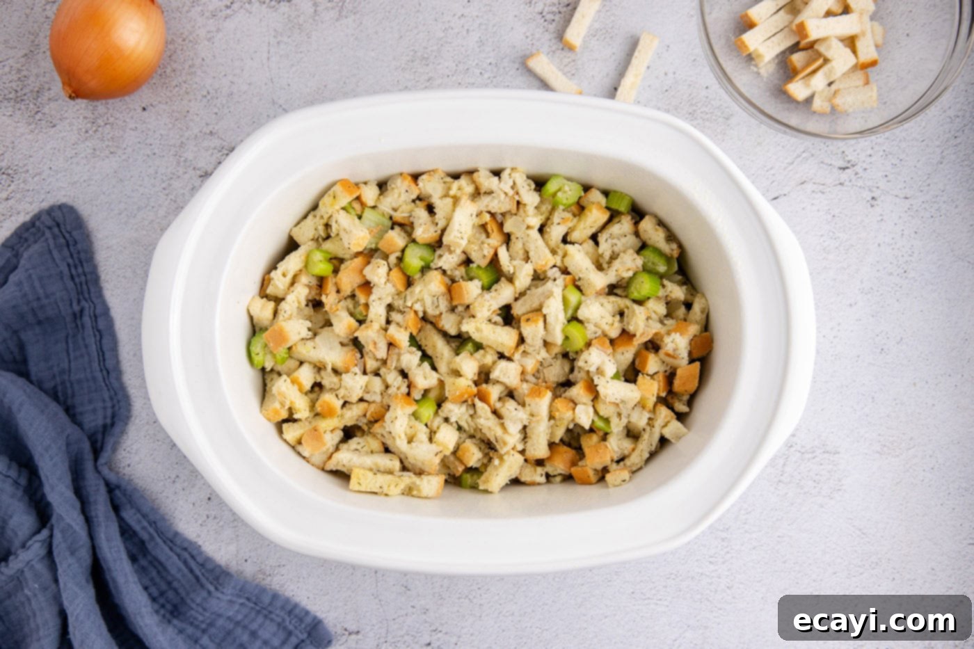 Easy Crockpot Stuffing 10 Stuffing mixture evenly spread out in the slow cooker crock, ready for cooking.
