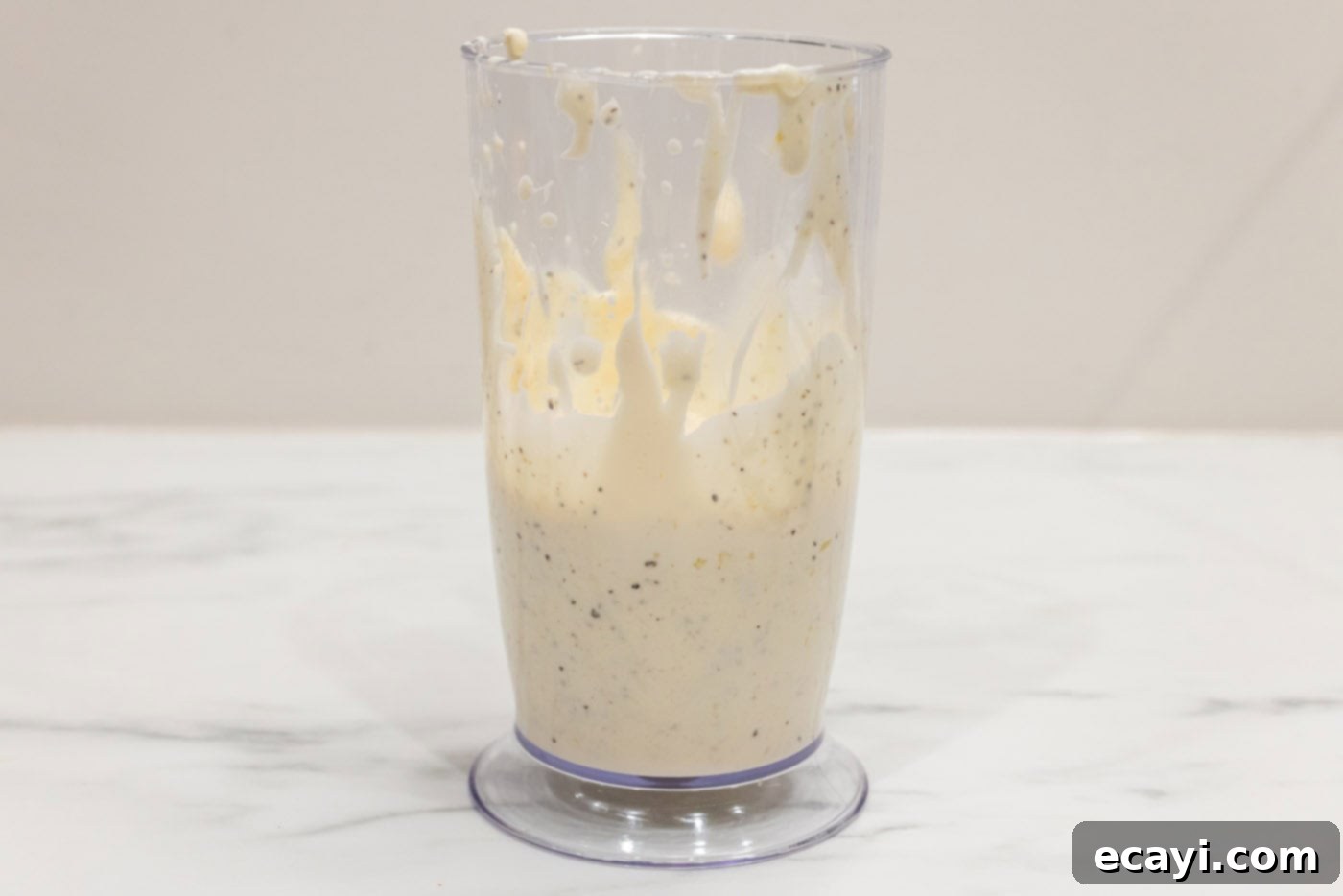 Creamy Garlic Aioli 6 The blended, smooth, and creamy garlic aioli filling a cup after being processed by an immersion blender.