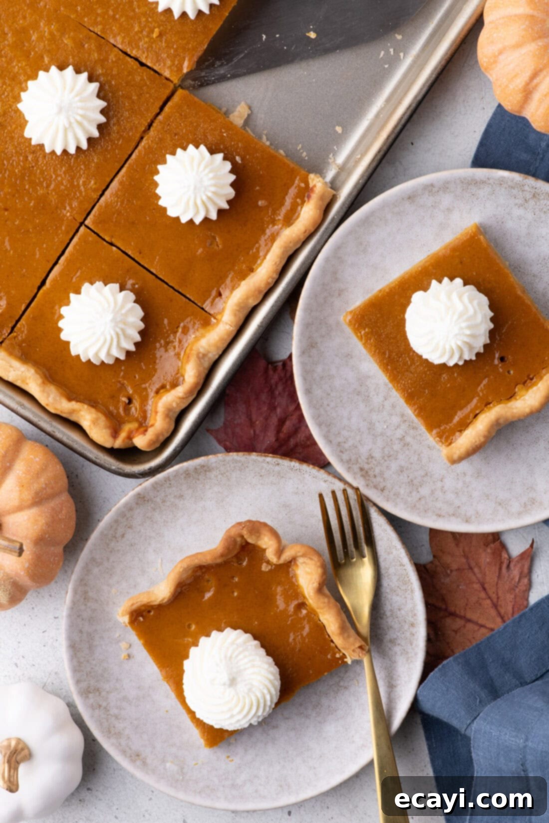 Family Sized Sheet Pan Pumpkin Pie 2 Two pieces of Pumpkin Slab Pie on plates topped with whipped cream, ready to be served