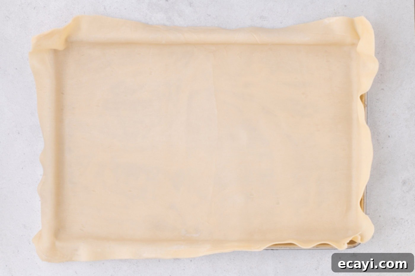 Family Sized Sheet Pan Pumpkin Pie 8 pie crust draping over a jelly roll pan