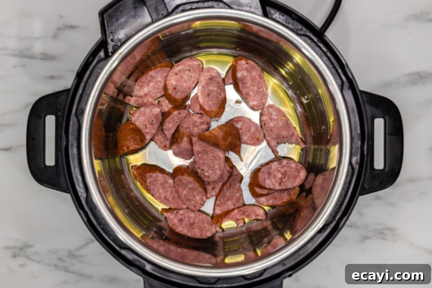 Easy Instant Pot Jambalaya 6 andouille sausage cooking with olive oil in a pressure cooker