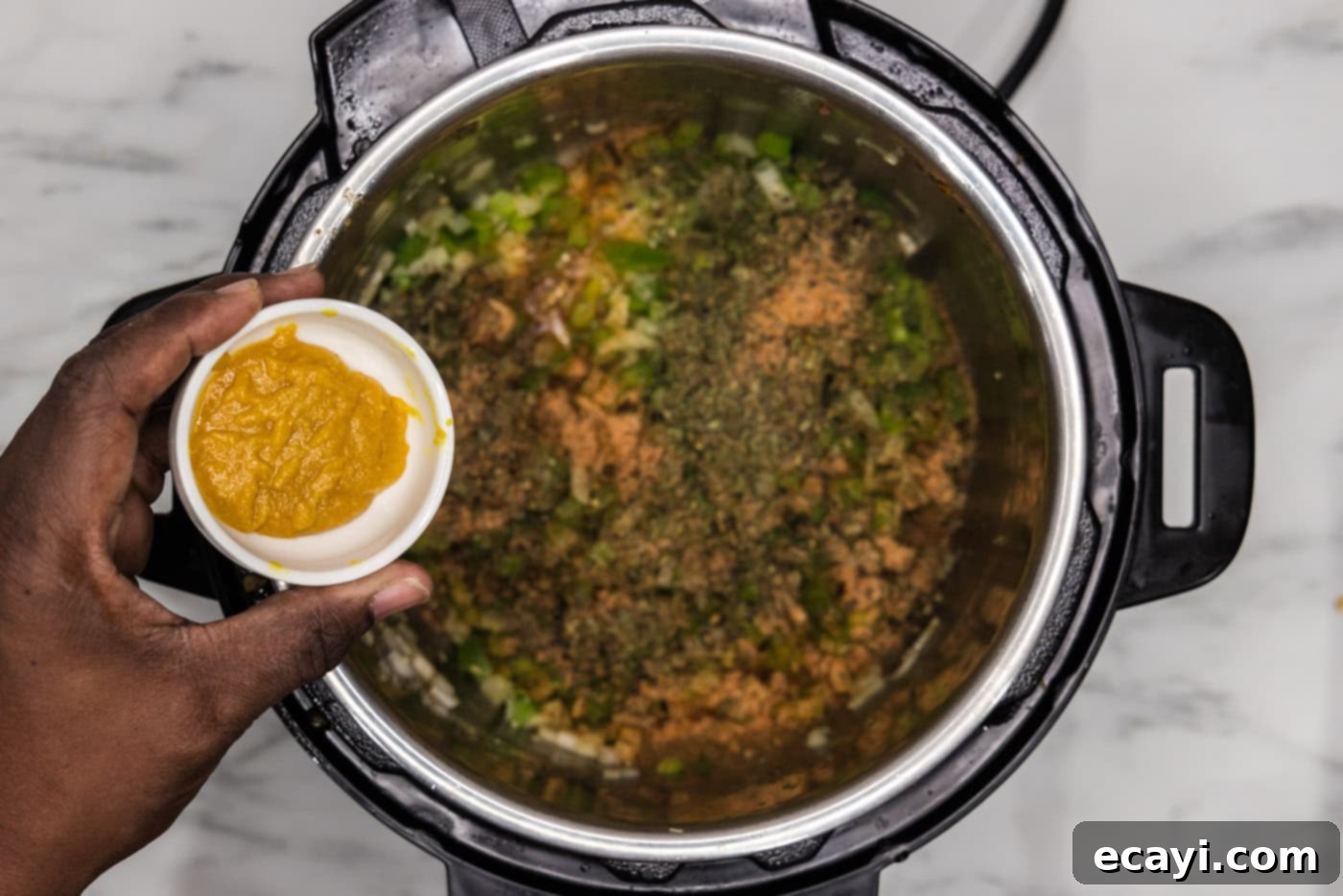 Easy Instant Pot Jambalaya 9 adding seasoning to chopped veggies in an instant pot