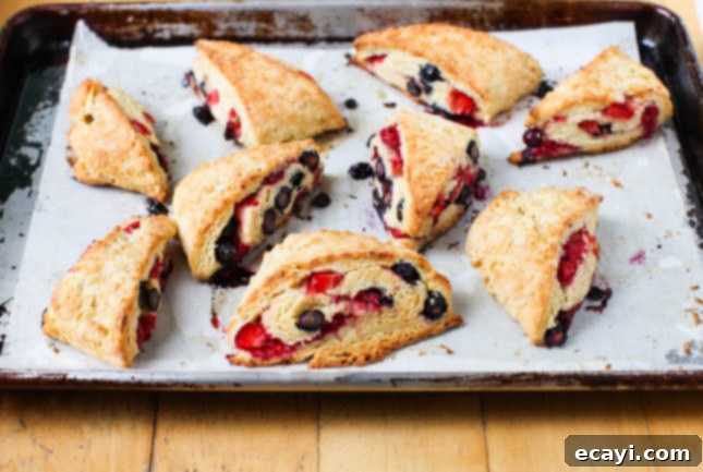 Fluffy Triple Berry Scones 3 Close-up of freshly baked Triple Berry Scones showcasing flaky texture and vibrant berries