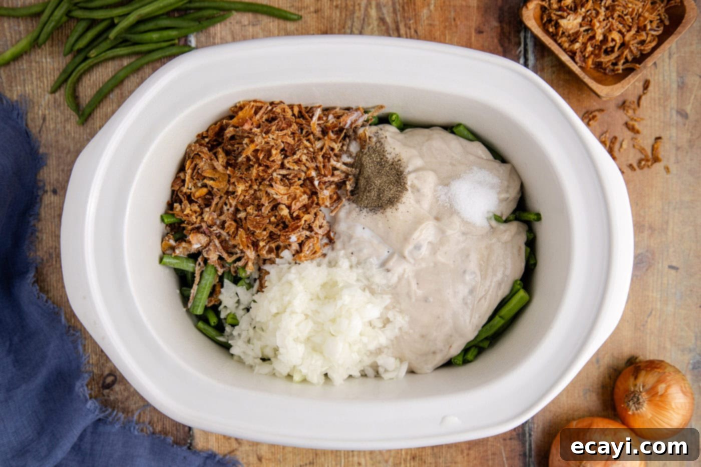 Effortless Crockpot Green Bean Bake 6 green bean casserole ingredients mixed together in a crockpot, showing the creamy base.