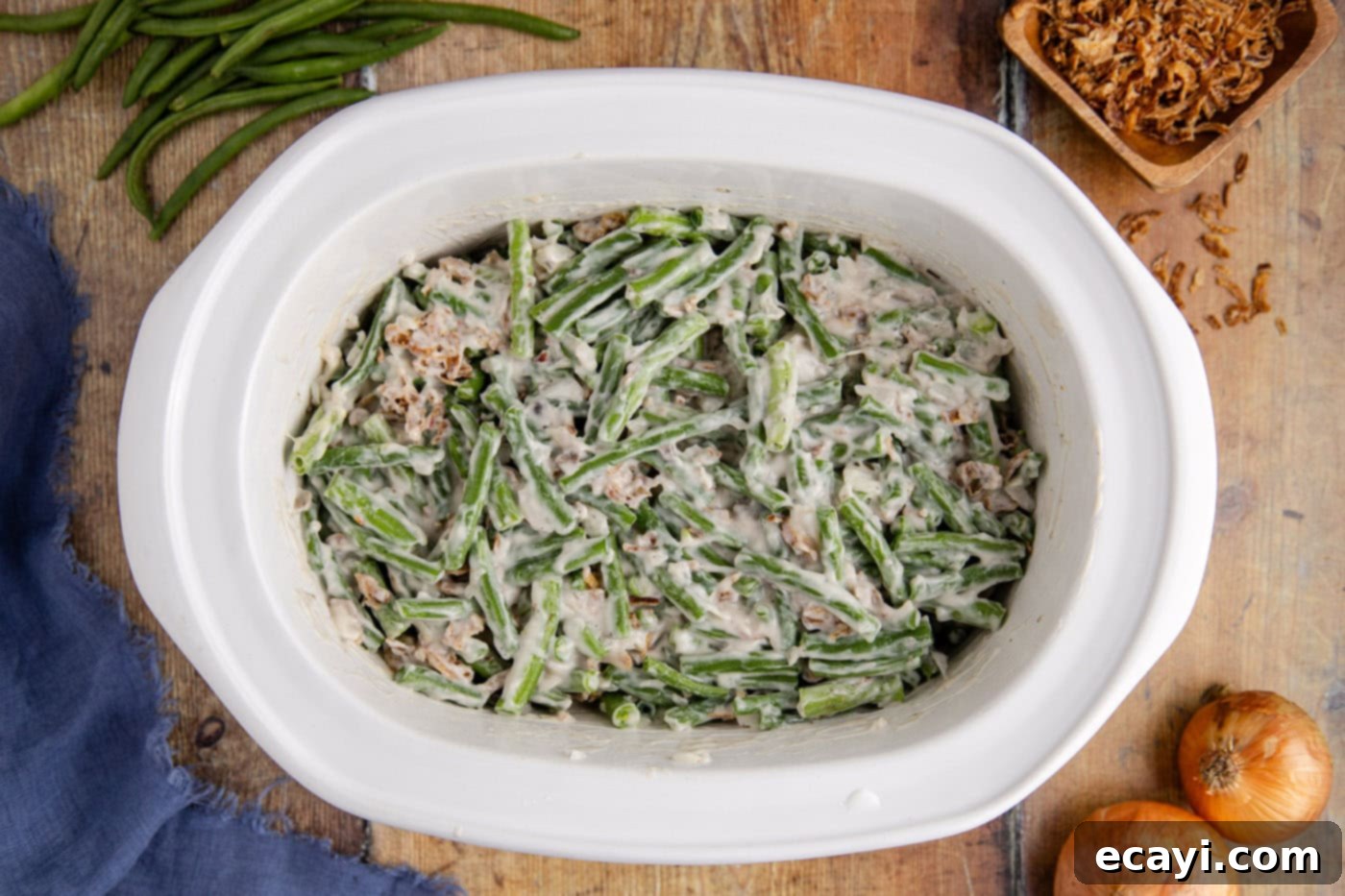 Effortless Crockpot Green Bean Bake 7 green bean casserole in a slow cooker crock, mixed and ready to cook.