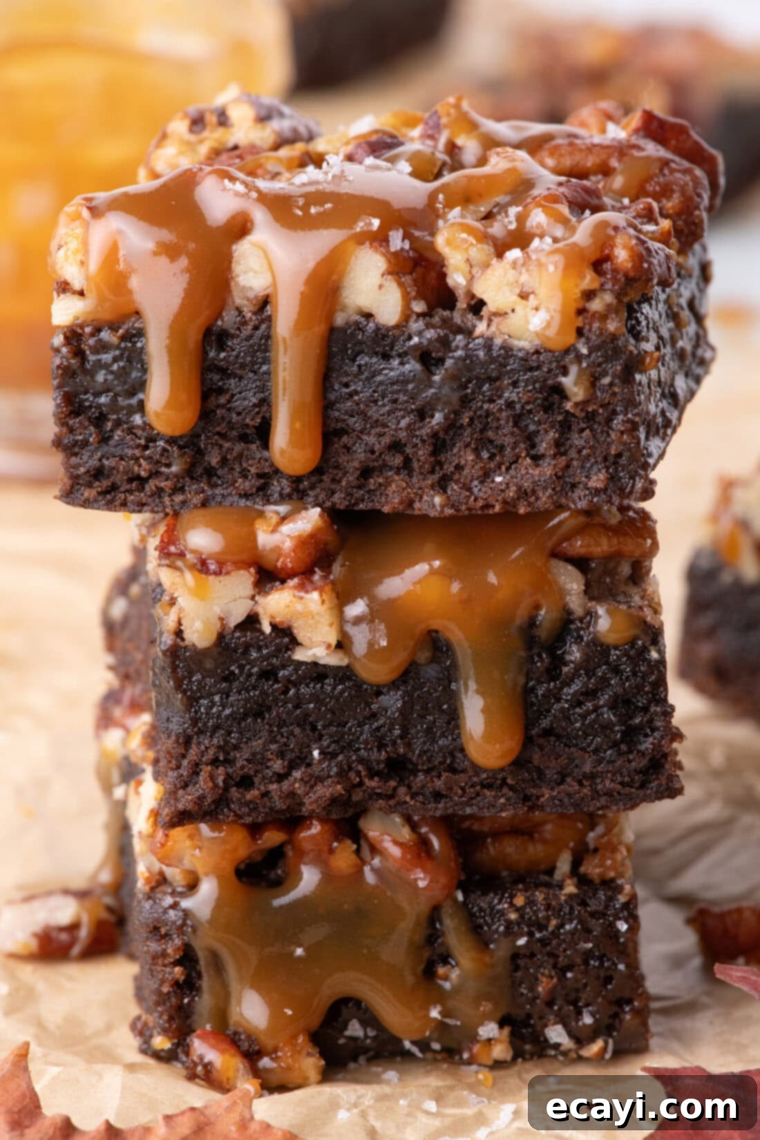 Decadent Pecan Pie Brownies 2 Stack of three Pecan Pie Brownies with caramel drizzled on top, showcasing a rich fudgy texture and nutty topping