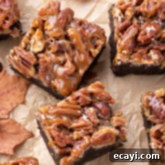 Decadent Pecan Pie Brownies 12 Pecan Pie Brownies on parchment paper topped with caramel and flaky sea salt