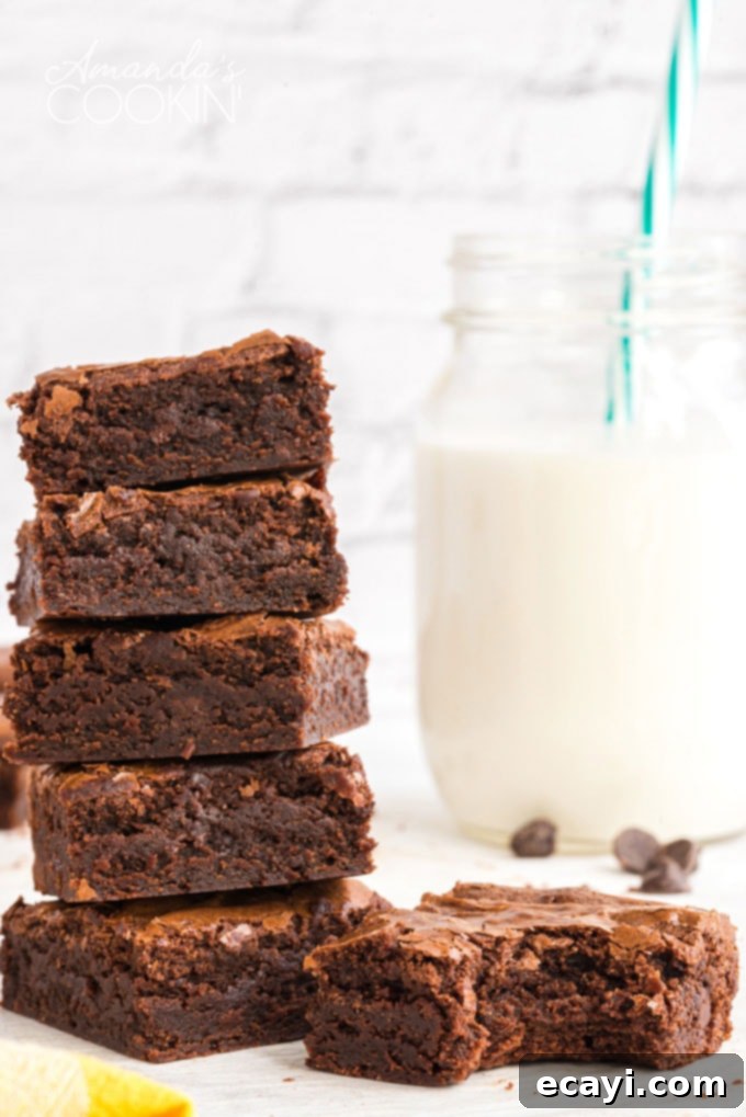 Homemade fudge brownies with milk – a classic combination Stack of fudgy brownies next to a bottle of milk, ready to be enjoyed