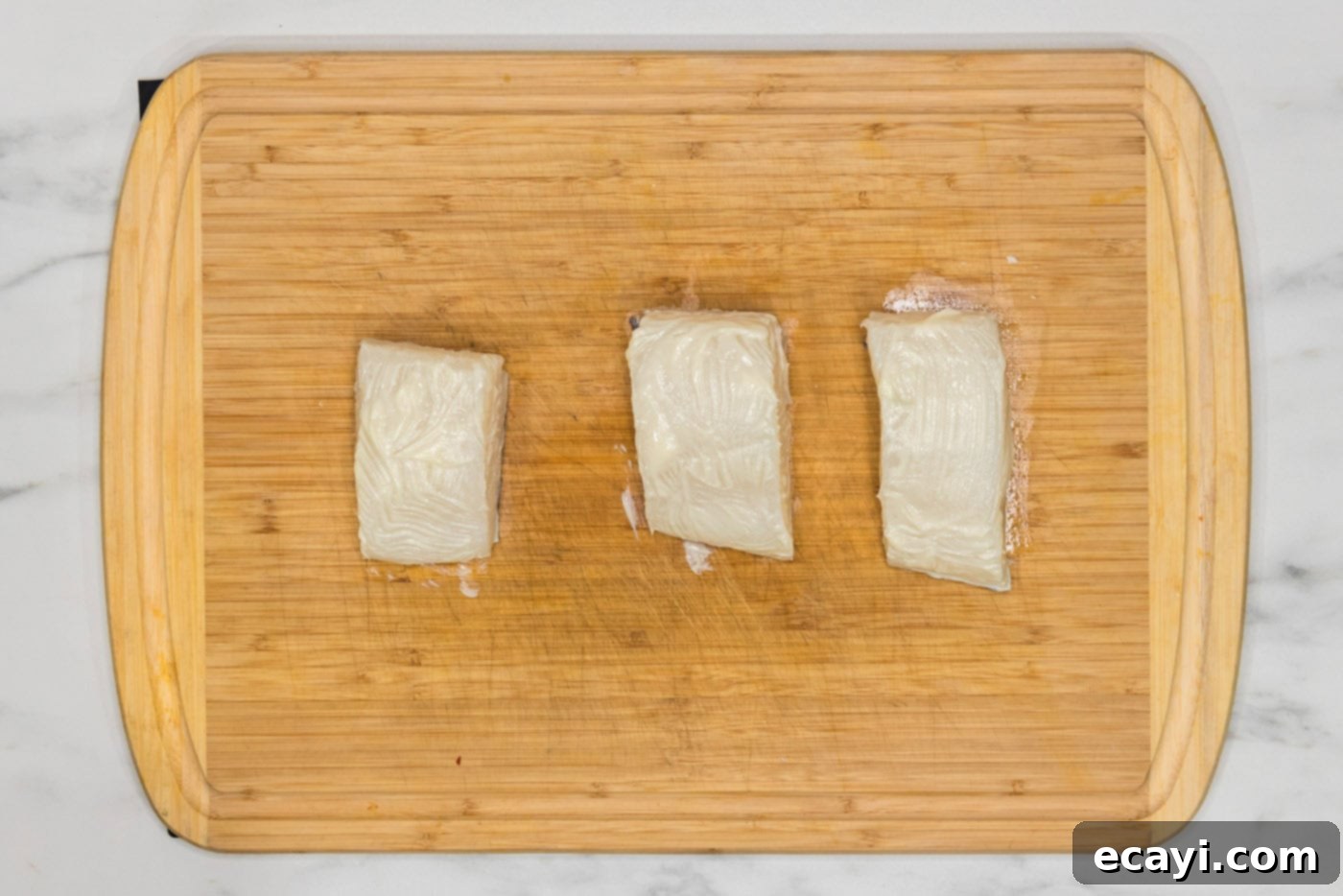 Crisp Skin Pan Seared Chilean Sea Bass 6 chilean sea bass brushed with butter on a cutting board