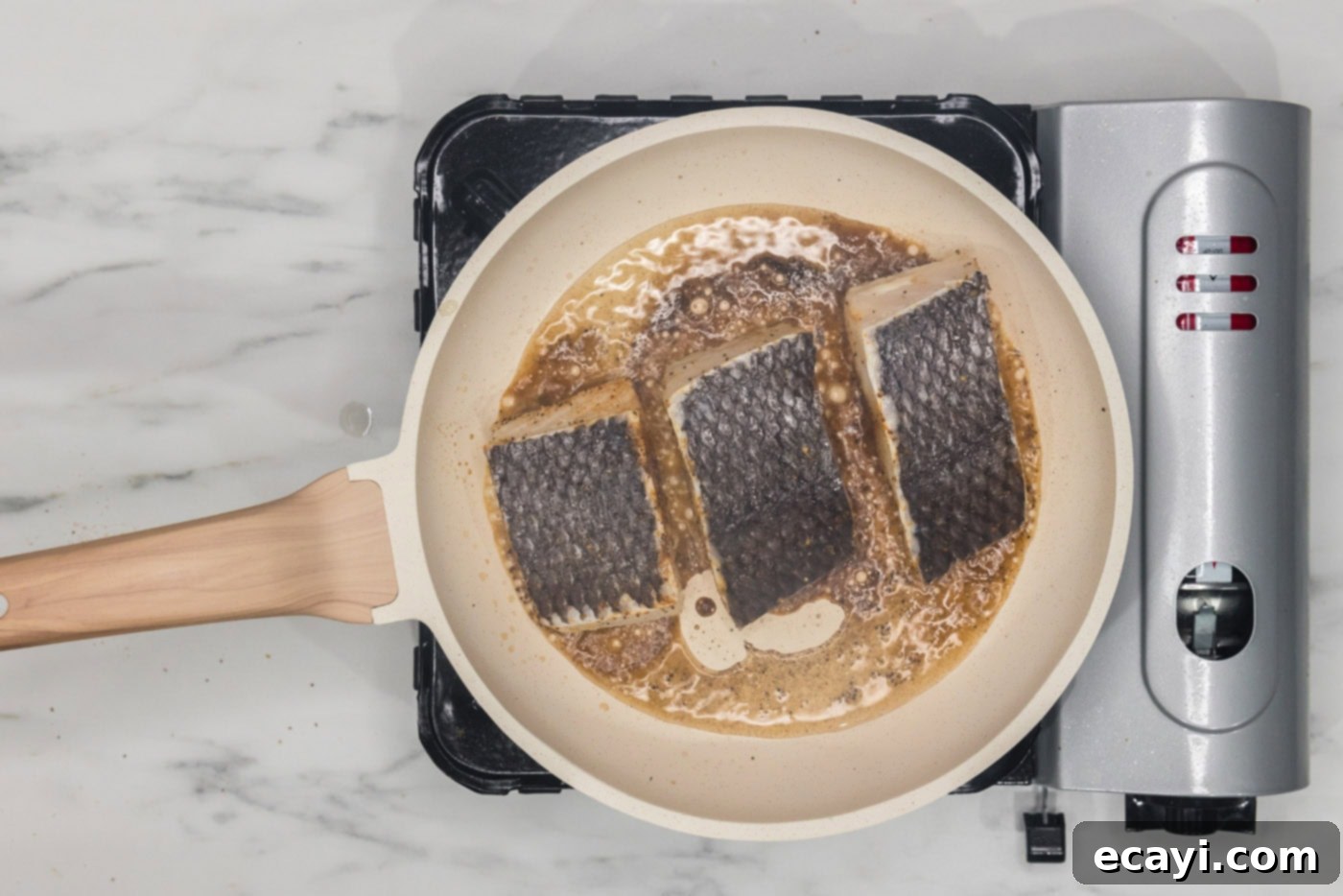 Crisp Skin Pan Seared Chilean Sea Bass 8 chilean sea bass filets cooking in a skillet skin side up