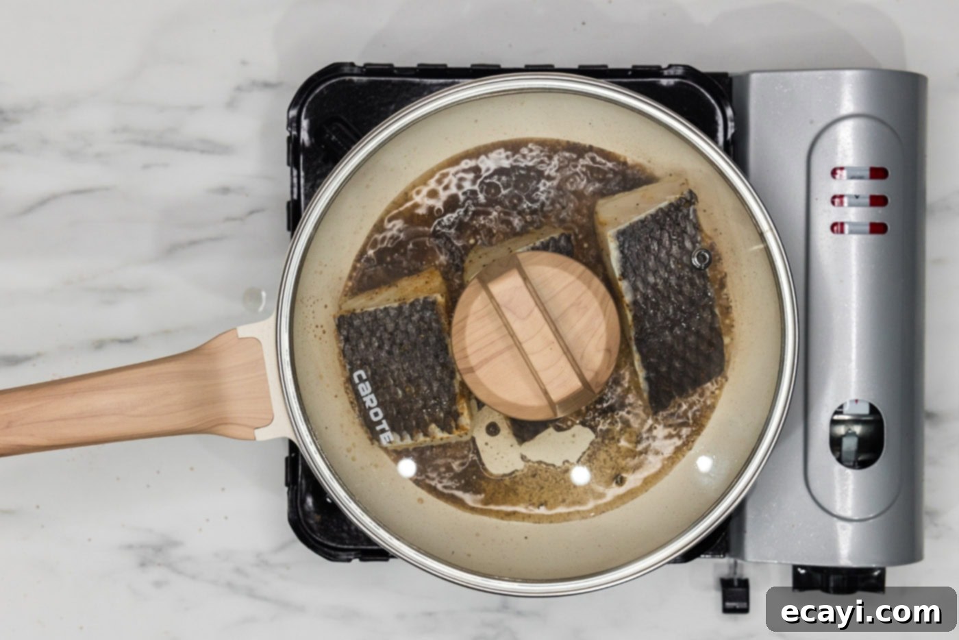 Crisp Skin Pan Seared Chilean Sea Bass 9 lid on skillet over chilean sea bass