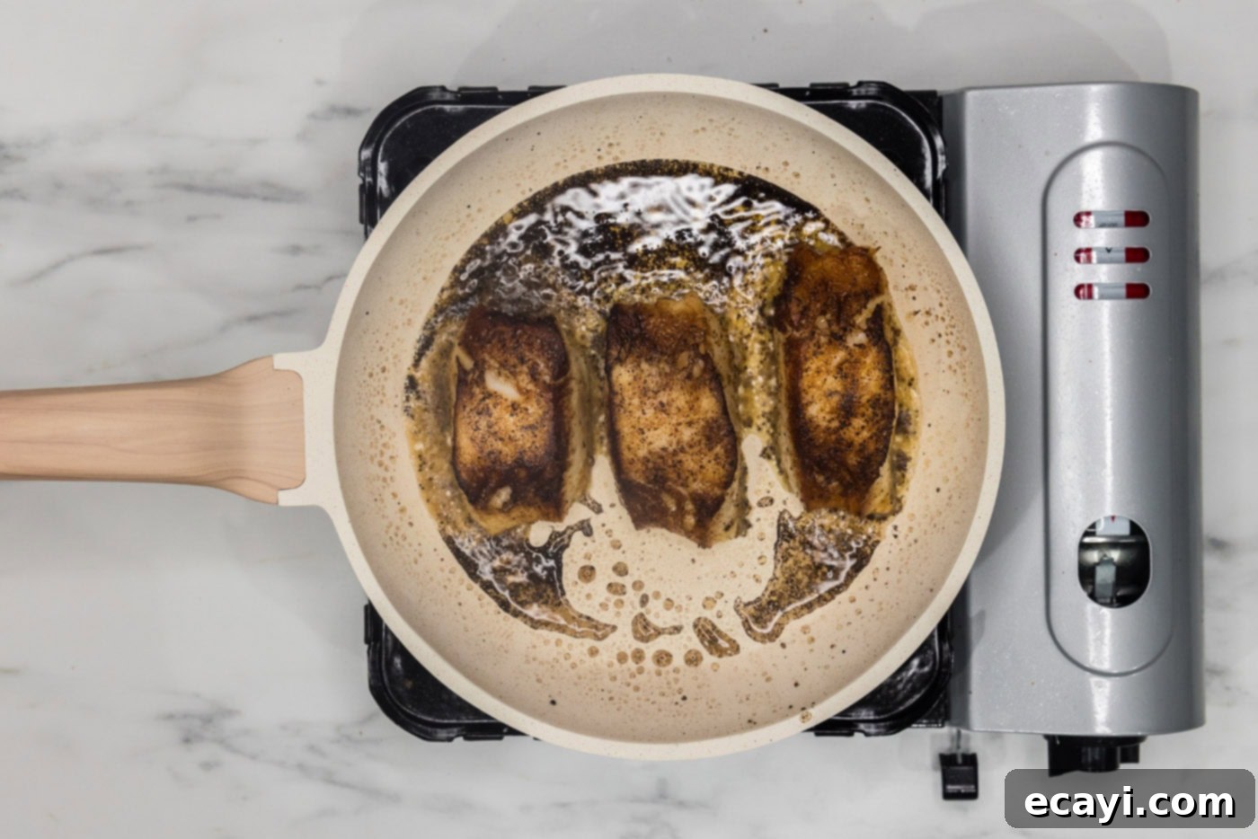 Crisp Skin Pan Seared Chilean Sea Bass 10 pan seared Chilean sea bass cooking in a skillet