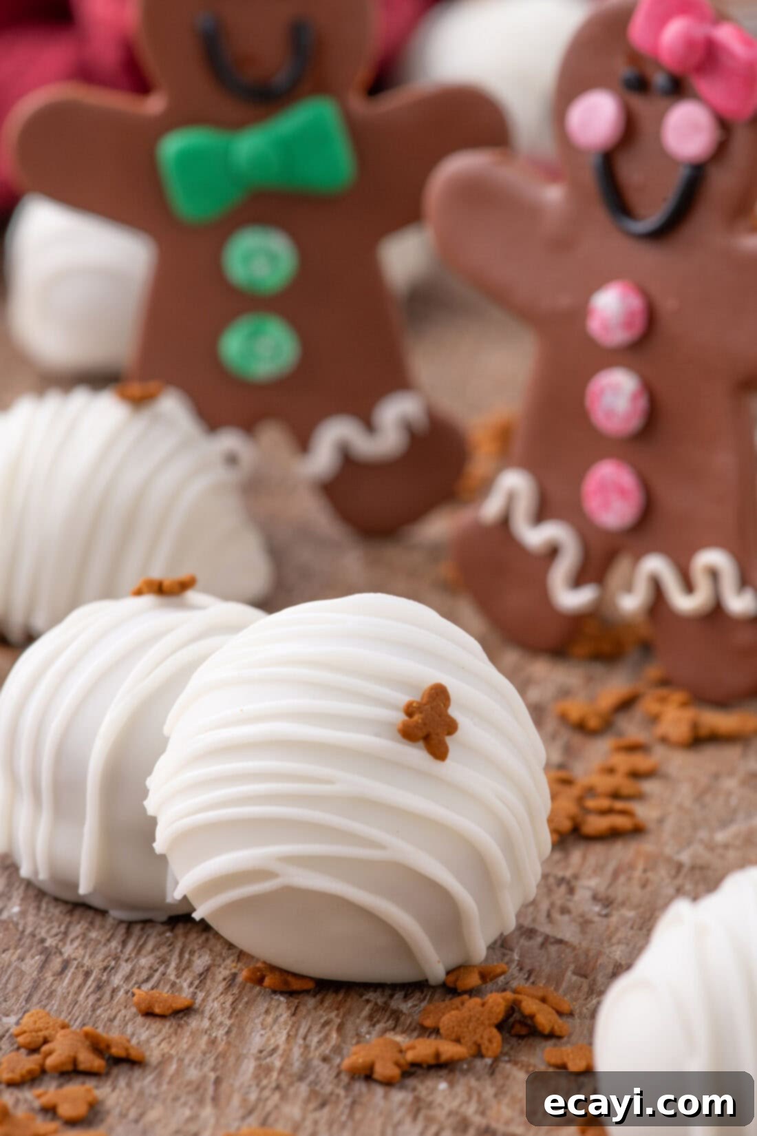 Gingerbread Oreo Bliss Bites 11 Close-up photo of a decorated Gingerbread Oreo Truffle, with blurred gingerbread cookies in the background