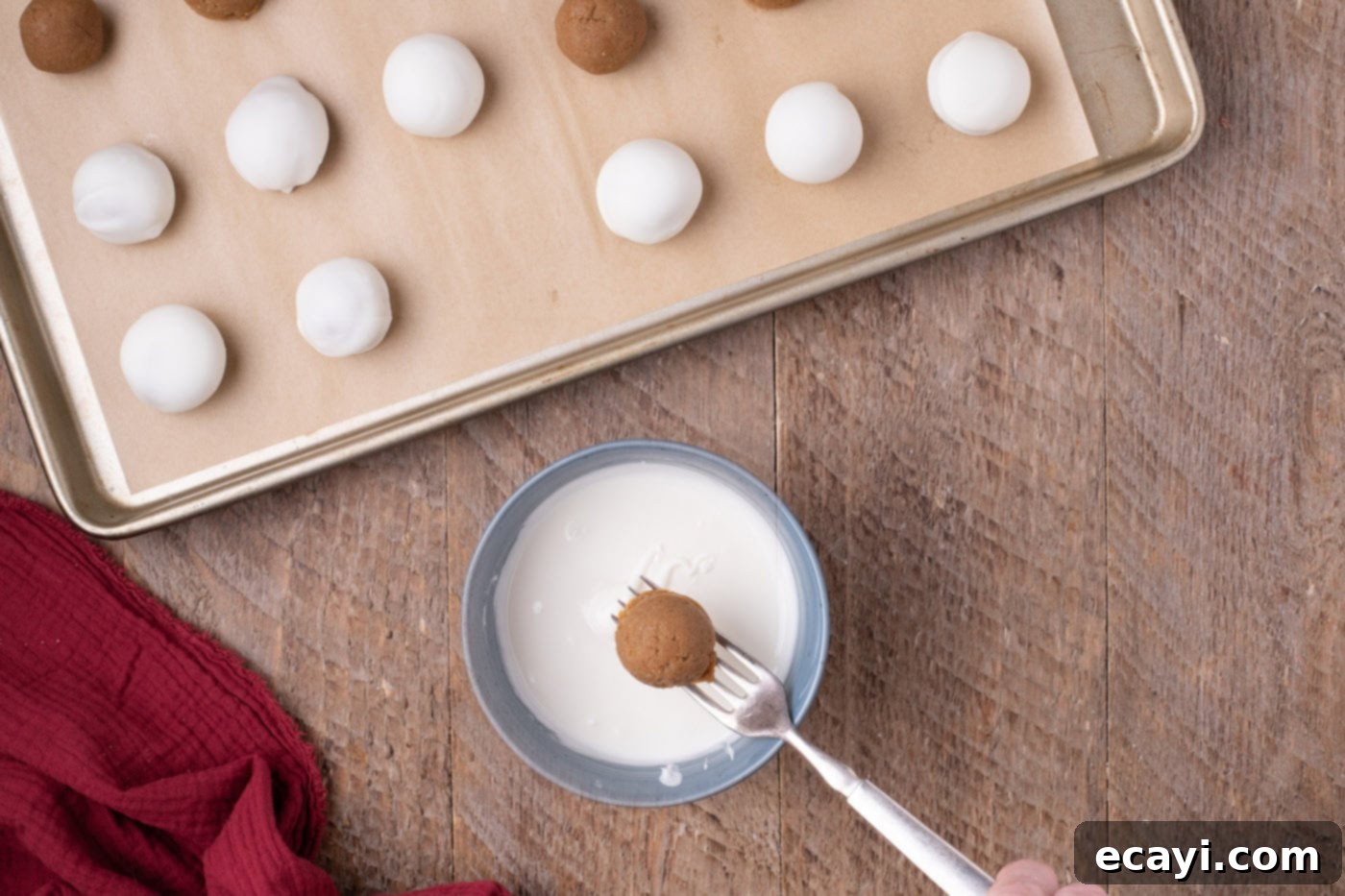 Gingerbread Oreo Bliss Bites 9 A gingerbread truffle being dipped into melted white chocolate using a fork