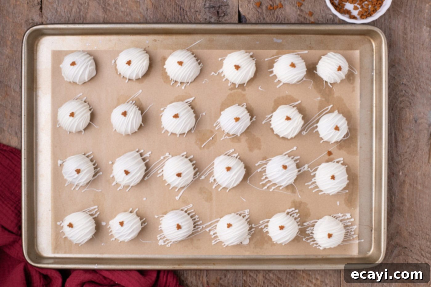 Gingerbread Oreo Bliss Bites 10 Finished gingerbread truffles on a baking sheet, decorated with white chocolate drizzle and gingerbread man sprinkles