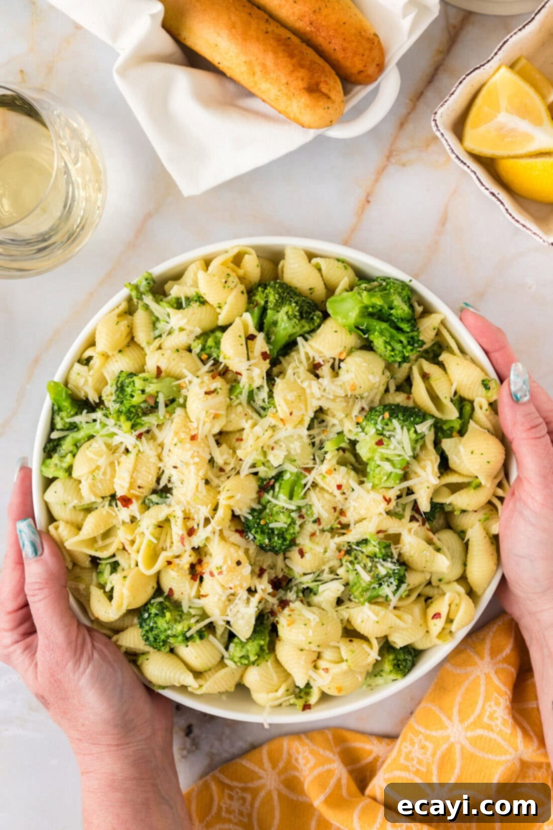 Creamy Broccoli Pasta 2 Hands holding a bowl of freshly made Broccoli Pasta, garnished and ready to eat.