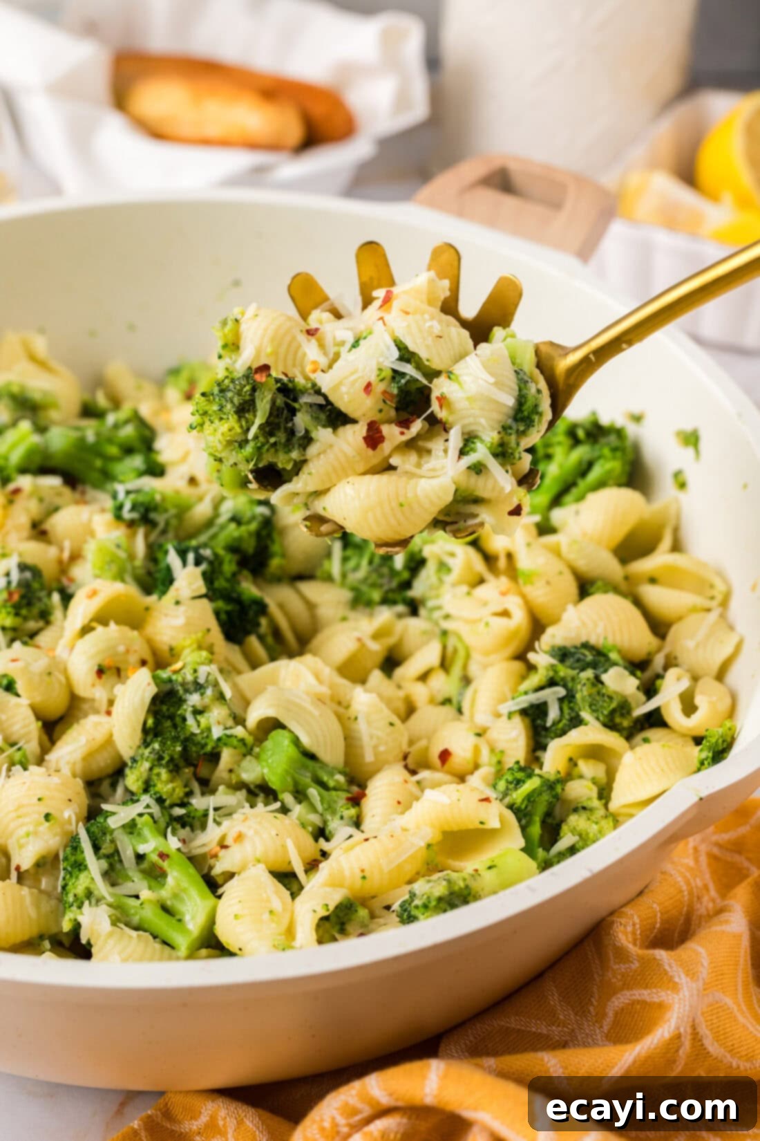 Creamy Broccoli Pasta 3 A serving spoon lifting a portion of hot Broccoli Pasta from a skillet.