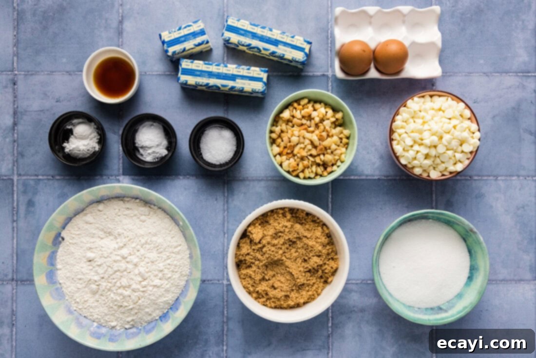 Decadent White Chocolate Macadamia Delights 4 A flat lay photograph displaying all the fresh ingredients needed for White Chocolate Macadamia Nut Cookies, including flour, sugars, butter, eggs, white chocolate chips, and macadamia nuts, neatly arranged on a counter.