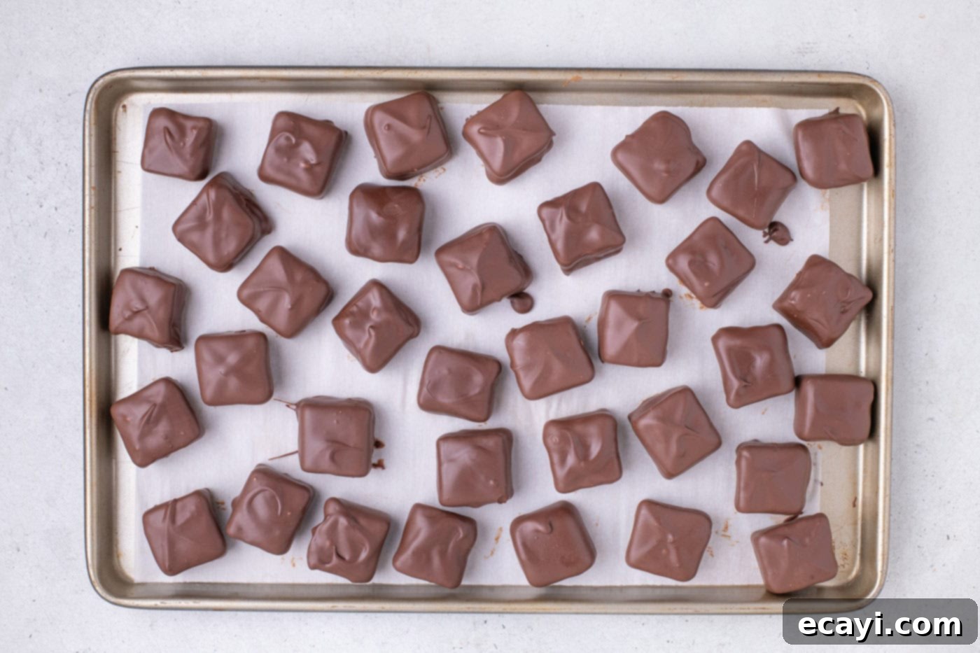 Cool Whip Treats 11 Finished chocolate-dipped Cool Whip Candies arranged neatly on a baking sheet, ready to set.