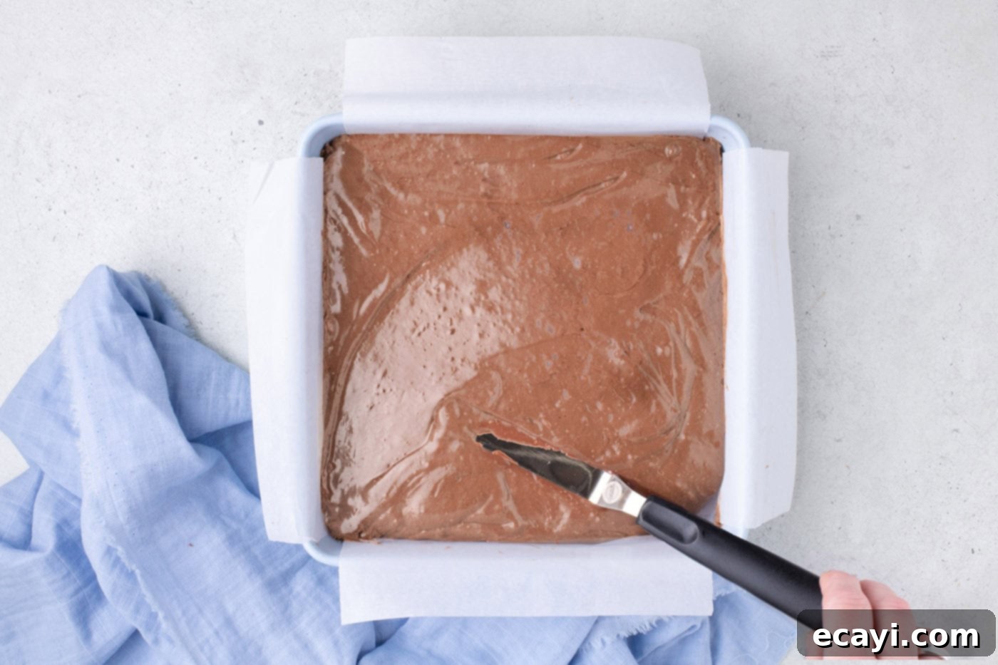 Cool Whip Treats 7 The fluffy chocolate mixture has been transferred into a parchment-lined baking pan, ready to chill.