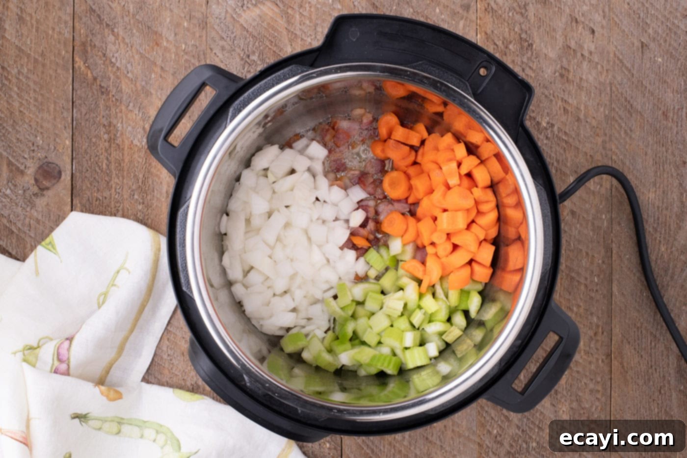 Hearty Instant Pot Split Pea Soup 6 Chopped onions, carrots, and celery added to the Instant Pot with cooked bacon, sautéing until tender and fragrant.