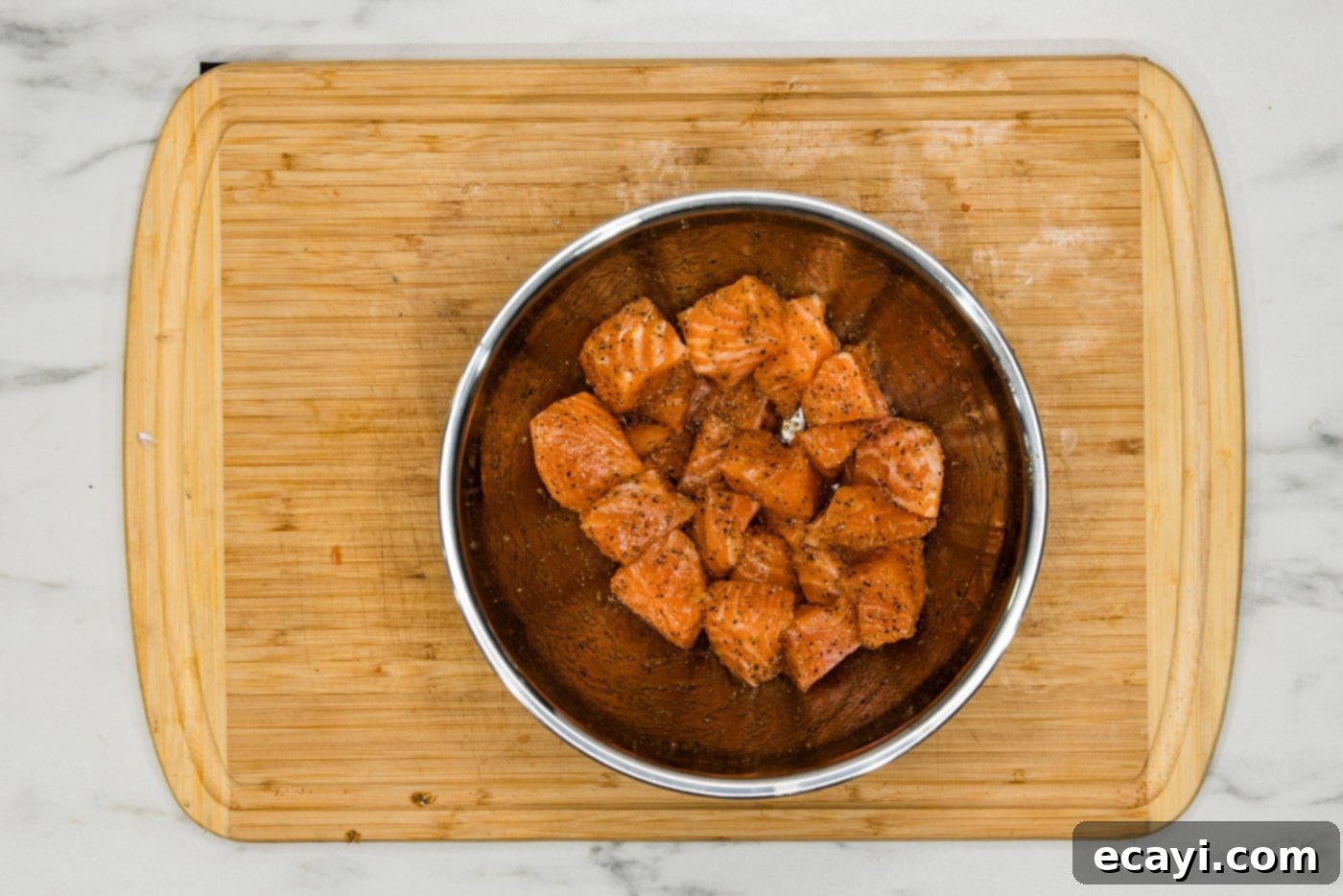 Mediterranean Salmon Pasta 5 salmon cubes in a bowl with olive oil and seasonings