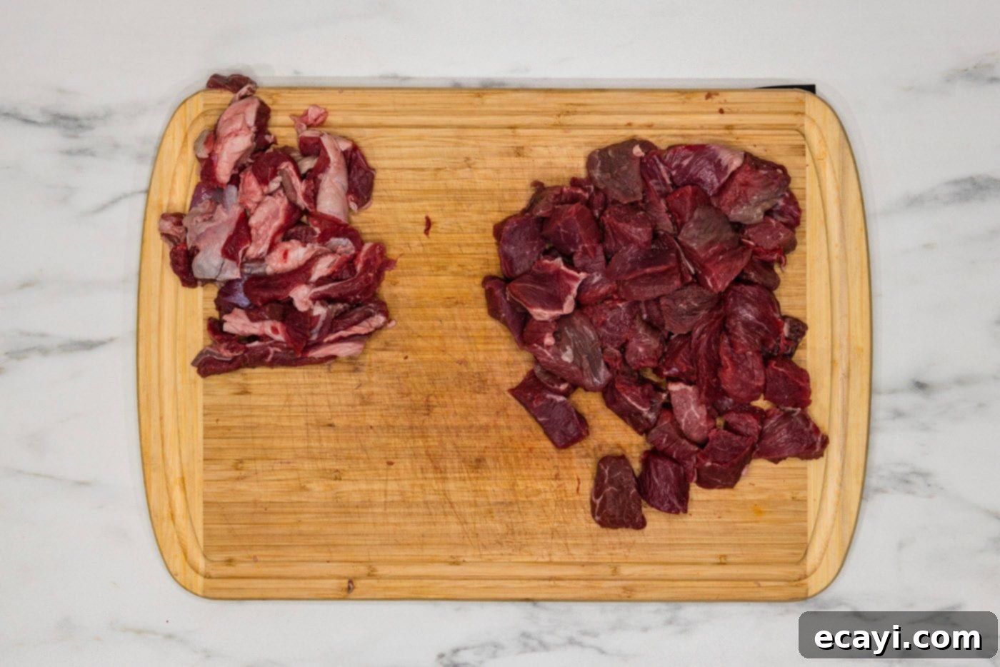 Mouthwatering Garlic Butter Steak Bites 5 Cubed sirloin steak on a cutting board with fat trimmed off, demonstrating proper preparation before seasoning.