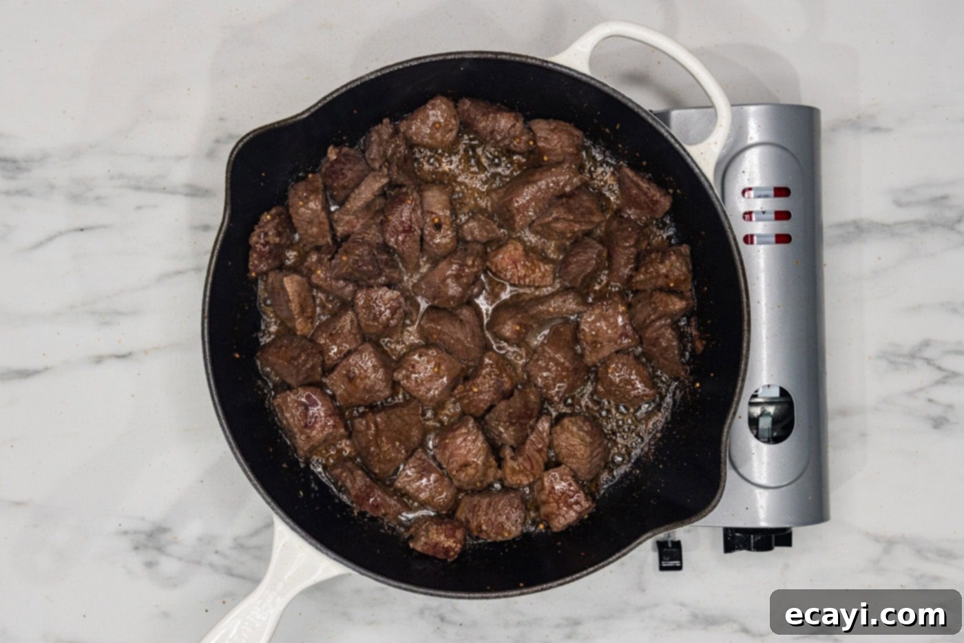 Mouthwatering Garlic Butter Steak Bites 7 Cooked cubed steak in a skillet, showing a beautiful brown crust developed from searing at high heat.