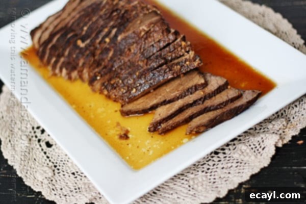 Velvet Brandy Pot Roast 10 A close up of sliced slow cooker roast with brandy sauce on a white platter.