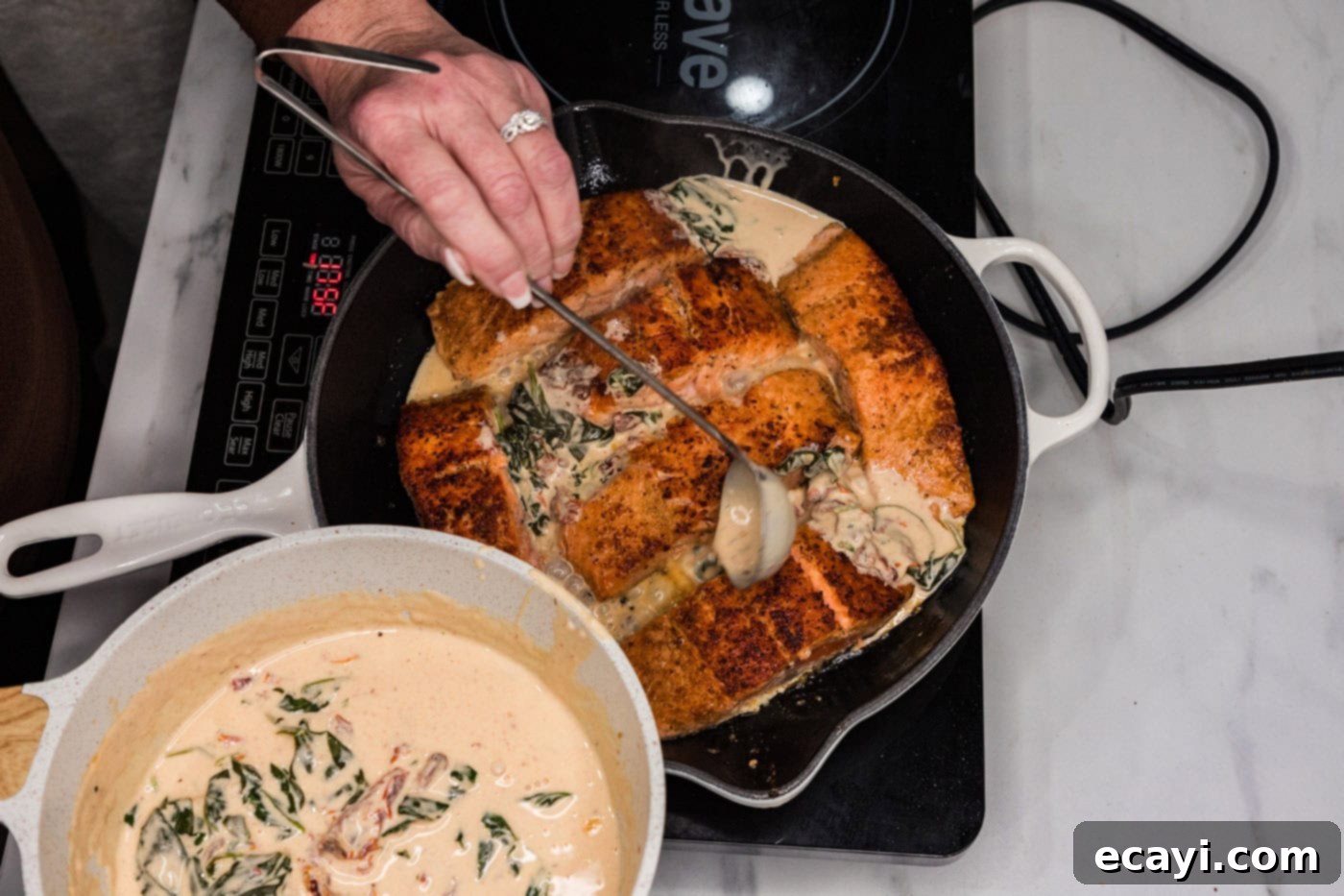Silken Salmon Perfection 10 spooning cream sauce over salmon in a skillet