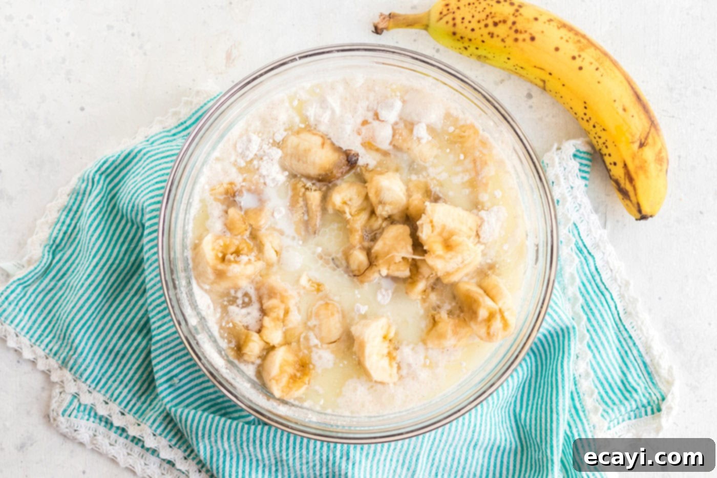 Effortless Banana Cake 5 bananas added to a bowl with cake mix, milk, eggs, and oil