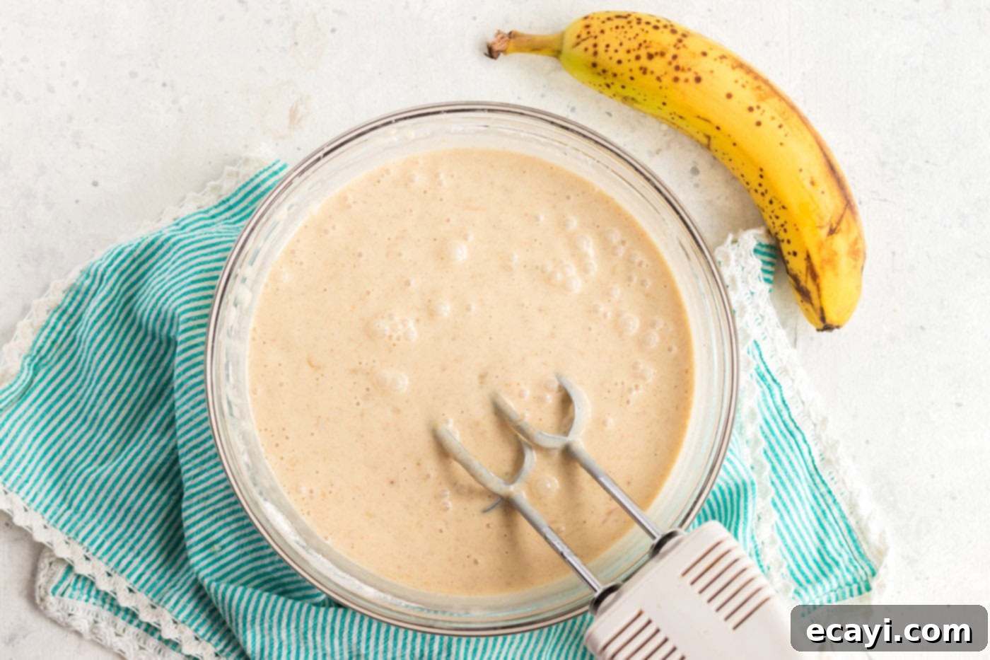 Effortless Banana Cake 6 cake batter being mixed in a bowl with a hand mixer