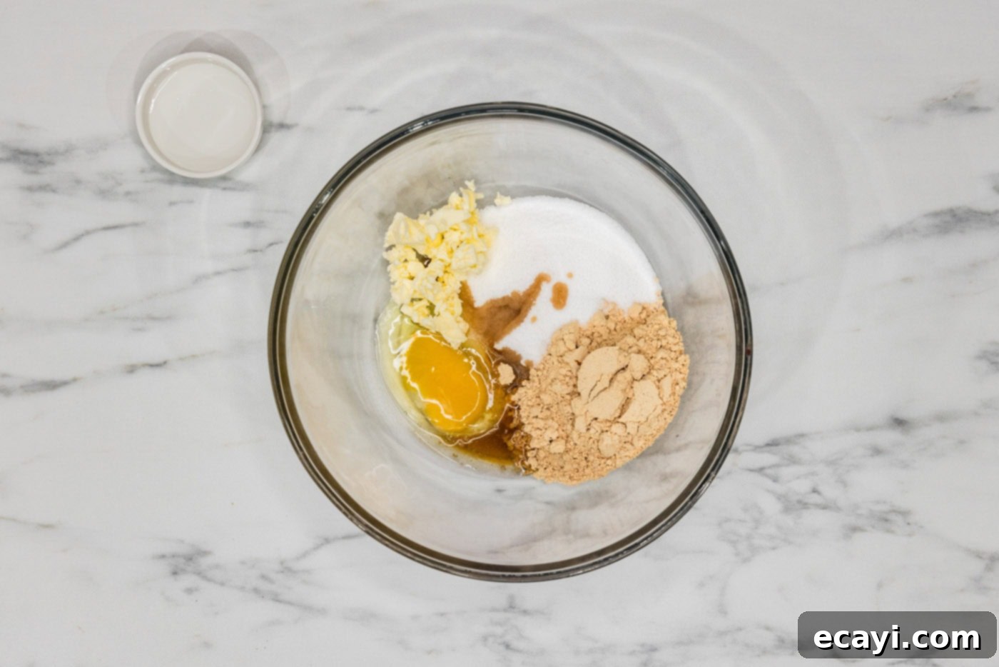 Guilt-Free Keto Peanut Butter Treats 5 peanut butter powder, egg, vanilla, sugar substitute, and butter in a bowl ready to be mixed