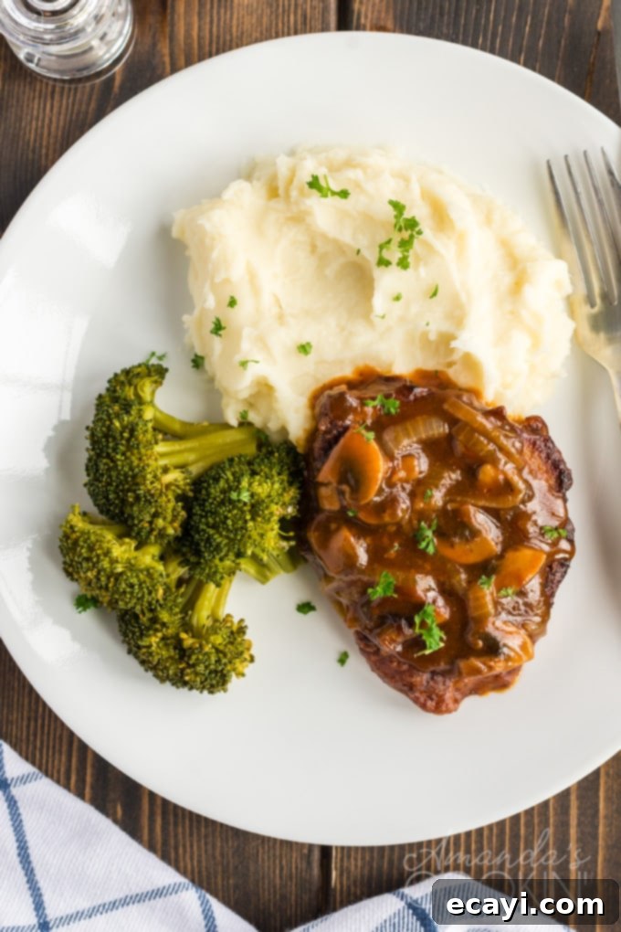 This oven Swiss steak is a delicious twist on a vintage classic. It uses fresh mushrooms and plenty of beef broth for flavor. A comforting, updated recipe! A plate of oven-baked Swiss steak with a side of vibrant green broccoli
