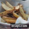 Crispy Cast Iron Roast Potatoes 8 A close up photo of a bowl of roasted fingerling potatoes with rosemary, a gourmet potato side dish.
